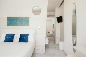 a white room with a bed with blue pillows at Life Hotel Seaview & Spa in Porto Recanati