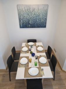 a dining room table with chairs and a painting on the wall at ATMOSPHERE 2 CENTRALE, VISTA MARE, con parcheggio in Riccione