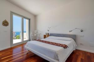 Un pat sau paturi într-o cameră la Luxury Seafront Villa with Rooftop Pool & Stunning Sea Views