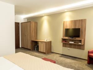 Uma TV ou centro de entretenimento em Hotel Calipso Hotel