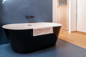 a bath tub in a bathroom with a blue wall at La Planque en Perche in Bellou-le-Trichard