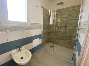a bathroom with a shower and a toilet and a sink at Villa Lentischio in Budoni