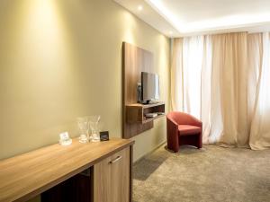 Uma TV ou centro de entretenimento em Hotel Calipso Hotel