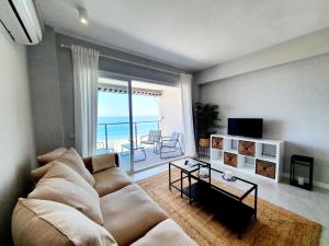 a living room with a couch and a view of the ocean at Estepona Vistamar 3 bedrooms in Estepona