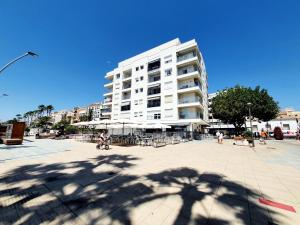 a large white building with people walking in front of it at Estepona Vistamar 3 bedrooms in Estepona