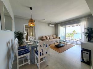 a dining room and living room with a table and chairs at Estepona Vistamar 3 bedrooms in Estepona