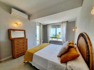 a bedroom with a bed and a window with the ocean at Estepona Vistamar 3 bedrooms in Estepona
