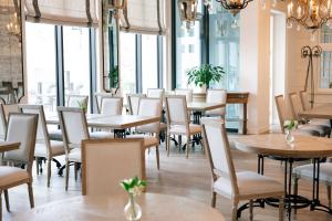 restauracja ze stołami, krzesłami i oknami w obiekcie Pałac na Opieszynie we Wrześni