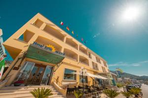 a yellow building with tables and chairs in front of it at Hotel Riva Del Sole in Cefalù
