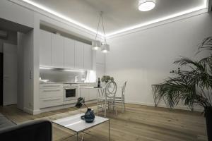 Biały salon ze stołem i kuchnią w obiekcie Błękitny Apartament w mieście Grodzisk Mazowiecki