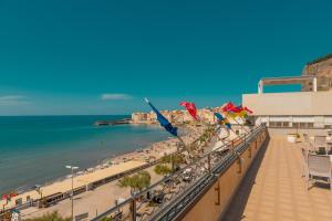 a view of a beach and the ocean from a balcony at Hotel Riva Del Sole in Cefalù