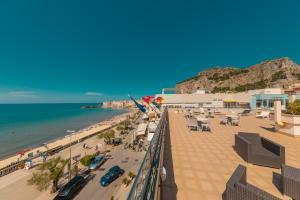 a view of a beach with people and the ocean at Hotel Riva Del Sole in Cefalù