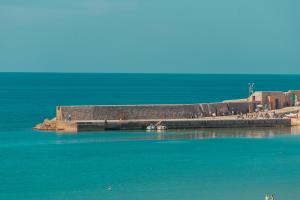 a group of people standing on a pier in the water at Hotel Riva Del Sole in Cefalù