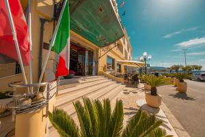 a building with a flag on the side of it at Hotel Riva Del Sole in Cefalù