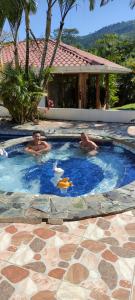 two men are swimming in a swimming pool at La Casa de la Abuela in Sucúa