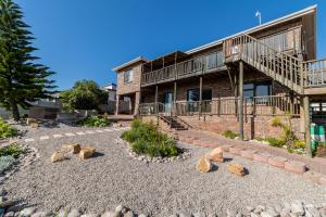 a house with rocks in the front yard at Beautiful and modern 4 bedroom 2 bathroom house in Klein Brak Rivier