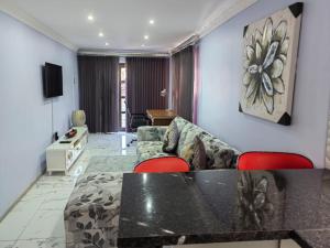 Obaa Sima Guest House في امتاتا: غرفة معيشة مع أريكة وطاولة