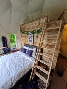 1 dormitorio con litera y escalera en Parkhoeve Glamping en Ham