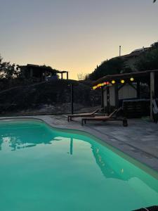 a pool of blue water in front of a house at Quinta do Cobral in Oliveira do Hospital
