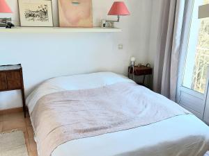 een wit bed in een kamer met een raam bij Robin's Lodge in Vidauban