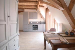 a kitchen with a wooden table in a room at Remise 67 - Historisches Anwesen beim Maison 1775, mit Sauna, Wissembourg, Elsass in Ingolsheim