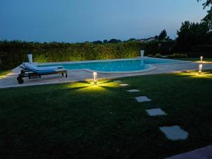 Cornale的住宿－馬里內拉住宿加早餐旅館，庭院中一个带长凳和灯光的游泳池