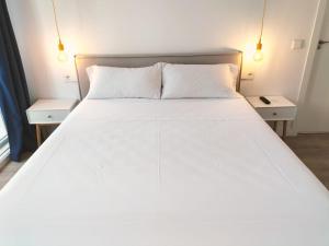 1 dormitorio con 1 cama blanca grande y 2 mesitas de noche en Hostal Manuela by gaiarooms, en Madrid