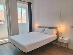 a bedroom with a white bed with a window at Hostal Manuela by gaiarooms in Madrid