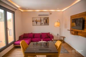 uma sala de estar com um sofá roxo e uma mesa em Marrakech - Premium Suite em Nouakchott