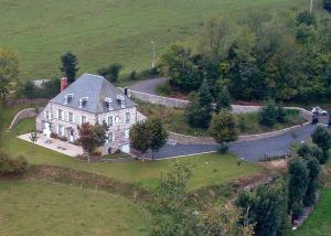 an aerial view of a large house with a road at Maison d'Hôtes La Nichée in Rochefort-Montagne +21 photos