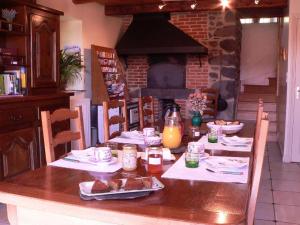 a table with food and a fireplace in a kitchen at Maison d'Hôtes La Nichée in Rochefort-Montagne