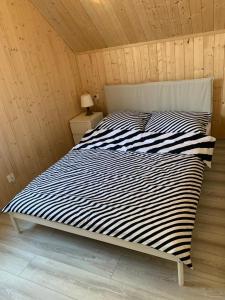 uma cama com um edredão preto e branco num quarto em Domek Letniskowy Władysławowo em Władysławowo