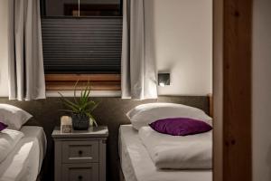 Giường trong phòng chung tại Arthur's Hotel und Apartments am Achensee