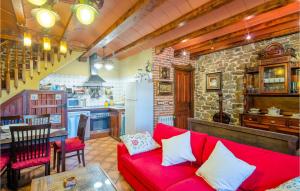 uma sala de estar com um sofá vermelho e uma cozinha em Awesome Home In Carabanzo em Cárabanzo