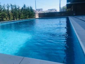 a swimming pool with blue water in a building at DXN Luxury Studio in Năvodari