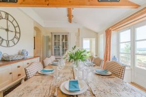 une salle à manger avec une table en bois et une grande horloge dans l'établissement Ivy Cottage, à Chippenham