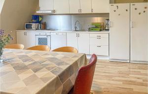 een keuken met een tafel en stoelen en een keuken met witte kasten bij Gorgeous Home In Finspng With Wifi in Finspång