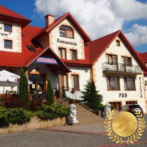 a hotel with a gold coin in front of it at Zajazd pod Jarem in Bałtów