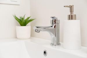 a bathroom sink with a faucet and a roll of toilet paper at Global Properties, Bonito apartamento en Urbanizacion Ciudad Mar in Puerto de Sagunto +41 photos