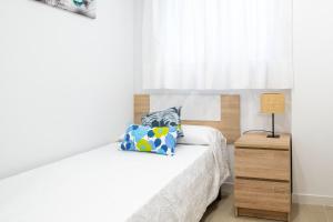 a bedroom with a bed with a pillow and a window at Global Properties, Bonito apartamento en Urbanizacion Ciudad Mar in Puerto de Sagunto