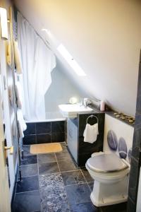 a bathroom with a toilet and a sink at Fosse Farmhouse Holiday Cottages in Chippenham