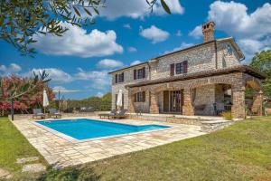 vistas al exterior de una casa de piedra con piscina en Villa Santolina, en Baderna