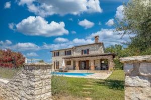 vistas al exterior de una casa de piedra con piscina en Villa Santolina, en Baderna