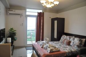 a living room with a bed and a window at Saekyung Condominium in Mactan