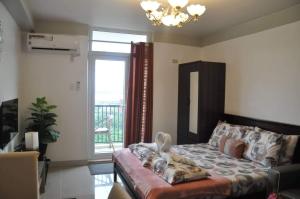 un soggiorno con letto e finestra di Saekyung Condominium a Mactan Altre 35 foto