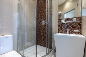 y baño con ducha de cristal y aseo. en Sidney Hotel London-Victoria, en Londres