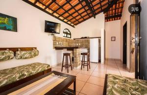 een woonkamer met een tafel en een bar. bij Pousada Caminho do Mar in Imbassai