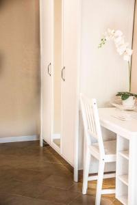 a white dining room with a table and a white chair at Hotel L'Oleandro in Villasimius