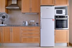 eine Küche mit einem weißen Kühlschrank und einer Mikrowelle in der Unterkunft WELCS VILLA MODERNA 031 EMP con Piscina y Vistas in Llança + 28 Fotos