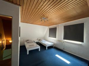 um pequeno quarto com um tecto de madeira e uma janela em Landhaus Huntlosen Monteure em Großenkneten